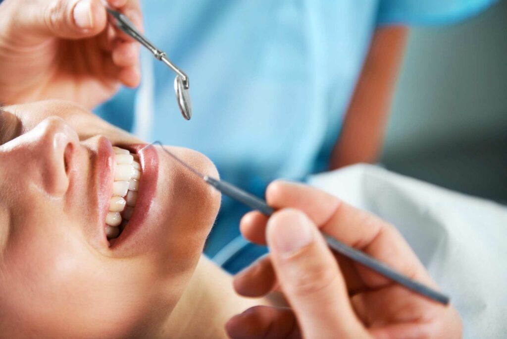 image of a woman smiling and dental tooth pick and mirror